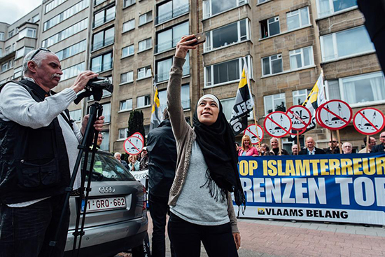 Une jeune musulmane se prend en selfie devant une manifestation islamophobe