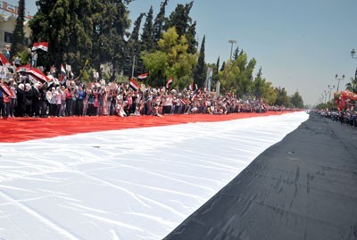 Le plus grand drapeau syrien hissé à Damas dans une manifesation massive de soutien au président Assad