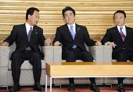 Le Premier ministre japonais Shinzo Abe (c), le ministre de la Revitalisation économique, Akira Amari (g) et le ministre des Finances, Taro Aso, le 18 novembre 2014 à Tokyo.