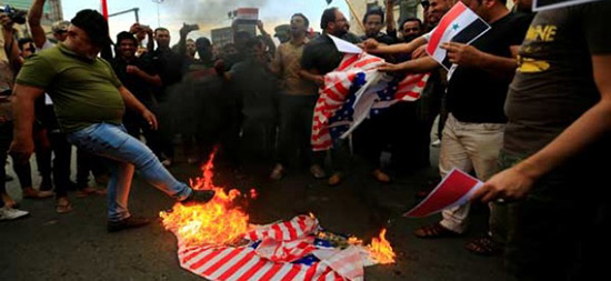 Irak: protestations et drapeaux américains brûlés après les frappes en Syrie